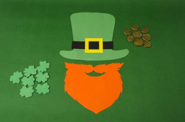 Aziz Patrick günü konsepti. Kağıt Saint Patrick günü Leprikon sahne: yeşil Leprikon şapka, bıyık ile turuncu sakal, madeni para ve diger ahşap arka plan üzerinde İrlanda geleneksel tatil sembolü olarak yonca