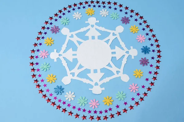 纸娃娃链和圆圈由鲜花和星星纸屑在蓝色背景 — 图库照片