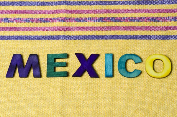 墨西哥由黄色桌布上五颜六色的木制字母制成 — 图库照片