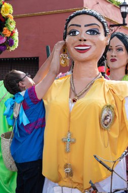 Oaxaca, Oaxaca, Meksika- 6 Temmuz 2019 Kadın Convite sırasında dev bir kukla soyunma, oaxaca Guelaguetza adlı büyük bir geleneksel partiye davet için yapılan bir parti, Meksika