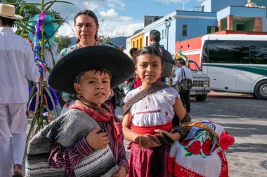 OAXACA, OAXACA, MEXICO- JULY 6, 2019: Woman and children dressed with traditional clothes during the Convite, a party made for invite to a big traditional party called Guelaguetza in Oaxaca, Mexico clipart