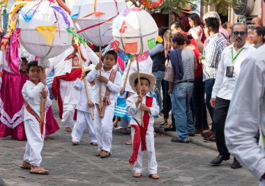 Oaxaca, Oaxaca, Meksika- 6 Temmuz 2019: Çocuklar geleneksel giysiler ile giyinmiş ve Convite sırasında marmotas denilen büyük topları taşıyan, oaxaca Guelaguetza denilen büyük bir geleneksel partiye davet için yapılan bir parti, Meksika