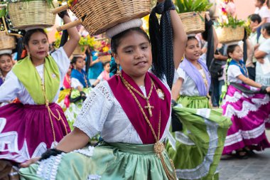 Oaxaca, Oaxaca, Meksika- 6 Temmuz 2019: Convite sırasında geleneksel giysiler giymiş kız, Oaxaca Guelaguetza adlı büyük bir geleneksel partiye davet için yapılan bir parti, Meksika