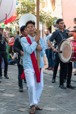 Oaxaca, Oaxaca, Meksika- Temmuz 6, 2019: Genç adam Convite sırasında yürüyüş geleneksel giysiler imiş, oaxaca Guelaguetza denilen büyük bir geleneksel partiye davet için yapılan bir parti, Meksika