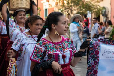 Oaxaca, Oaxaca, Meksika- Temmuz 6, 2019: Genç kadın Convite sırasında geleneksel giysiler ile giyinmiş, bir parti Oaxaca Guelaguetza denilen büyük bir geleneksel partiye davet için yapılan, Meksika