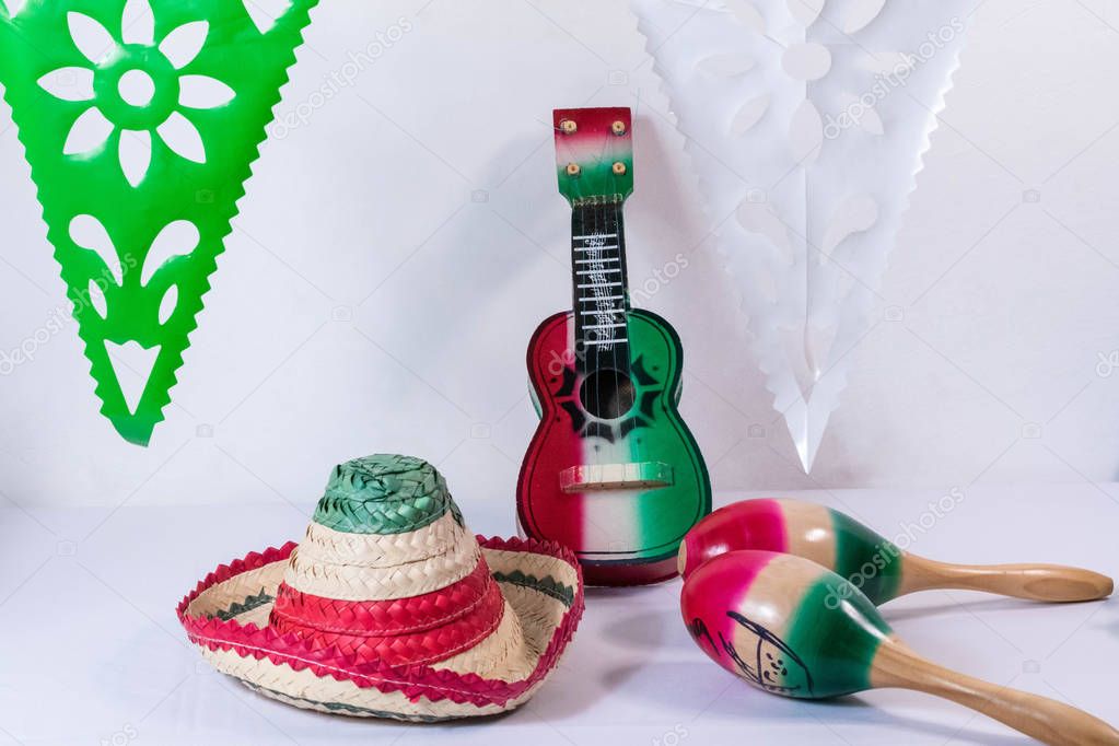 Hat, guitar, maracas and flags on white background. Mexican Independence Day decoration