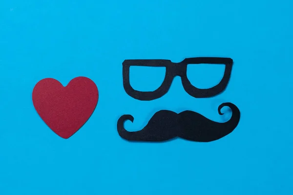 Red heart and a face with glasses and mustache on blue background