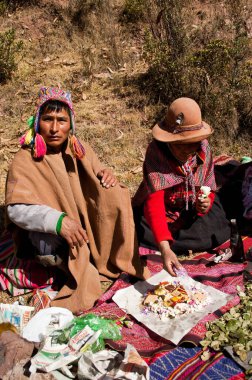 SACRED VALLEY, Peru - 31 Ağustos 2011: Peru 'daki Kutsal Vadi' de geleneksel giysiler giymiş bir erkek ve kadın atalarının ritüelini yapıyorlar