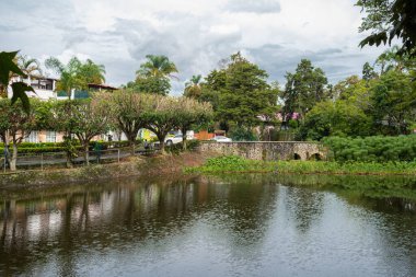 XALAPA, VERACRUZ, MEXICO- SEPTEMBER 15, 2025: A serene view of the calm waters at Los Lagos in Xalapa, Veracruz, Mexico, where dense trees and overcast skies are perfectly mirrored in the still surface.