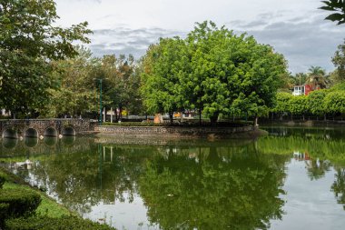 XALAPA, VERACRUZ, MEXICO- SEPTEMBER 15, 2025: A serene view of the calm waters at Los Lagos in Xalapa, Veracruz, Mexico, where dense trees and overcast skies are perfectly mirrored in the still surface.