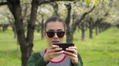 Güneş gözlüğü telefonunu fotoğraf çekmek olan beyaz kadın
