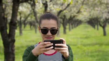 Güneş gözlüğü telefonunu fotoğraf çekmek olan beyaz kadın