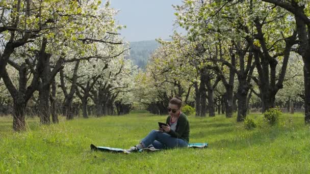 Libro electrónico de lectura femenina feliz en el parque — Vídeo de stock