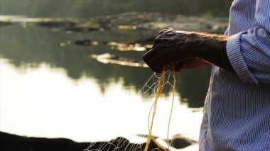 Hintli adam balık ağını hazırlıyor.
