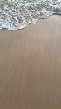 Sahile doğru koşan dalgaların süper yavaş çekim videosu. Sahilde gün batımı.