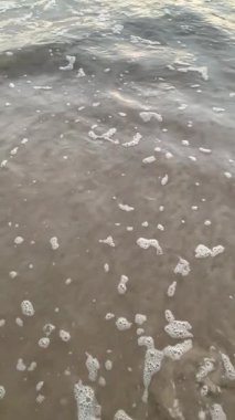 Sahile doğru koşan dalgaların süper yavaş çekim videosu. Sahilde gün batımı.