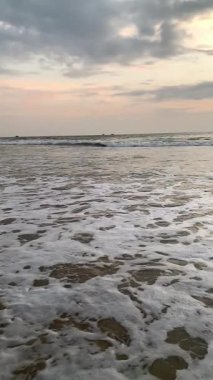 Sahile doğru koşan dalgaların süper yavaş çekim videosu. Sahilde gün batımı.