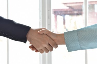 İş adamı ve kadının eli ortaklığın başarısını sarsıyor. Pazarlık konsepti.