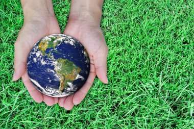 Dünya günü konsepti. Yeşil arka planda el ele tutuşan bir dünya. Bu görüntünün elementleri NASA tarafından desteklenmektedir