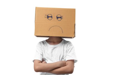 Kafasına karton kutu takan küçük bir kız mutsuz, beyaz arka planda izole edilmiş..