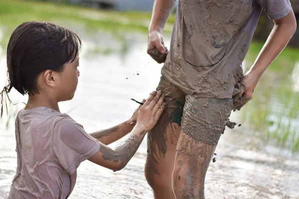 阳光灿烂的日子 两个小女孩在玩泥巴 孩子们在泥泞的土地上玩耍弄脏了 — 图库照片