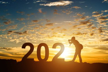 Fotoğrafçı silueti 2021 'de gün doğumunda ya da günbatımında fotokopi uzayı ile fotoğraf çekiyor. Mutlu yıllar 2021 fikri..