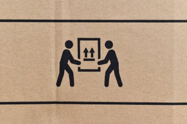 Arkaplan olarak ambalaj sembolleri olan karton kutuyu kapat. Kırılgan ögeyi gösteren sembol içeren paket kutusu.