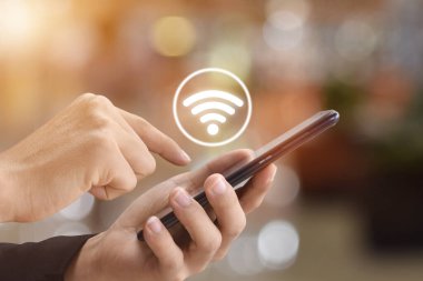 Erkek ellerinin Wifi simgesiyle cep telefonu kullanırken yakın plan görüntüsü. Teknoloji ve sosyal ağlar kavramı