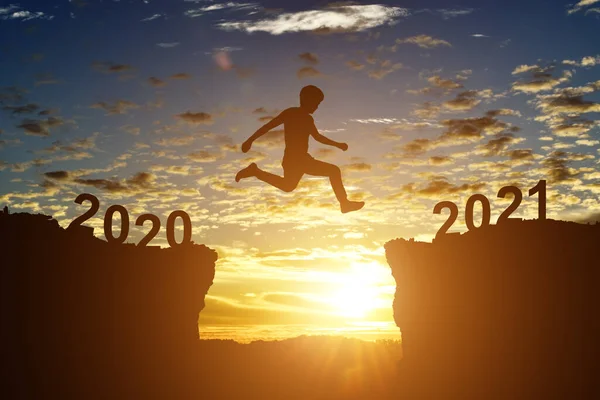 Silhouette Des Jungen Mannes Springen Zwischen 2020 Und 2021 Jahre — Stockfoto