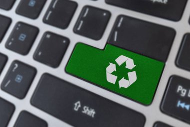 Çevre kavramının korunması. Laptop klavyesinde logo geri dönüşüm simgesi.