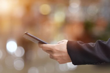 Erkek ellerinin cep telefonu kullanırken yakın plan görüntüsü. İş teknolojisi ve sosyal ağlar kavramı