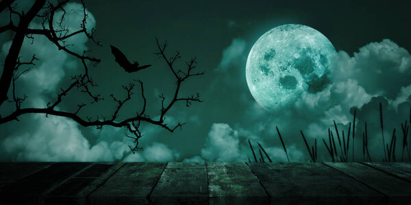 Halloween background. Spooky forest, Vintage wood tabletop with full moon sky. Copy space for text.