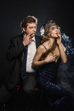 Sigara içen glamour gangster, bir erkek ve kadın sigara duman siyah zemin üzerine ile birkaç