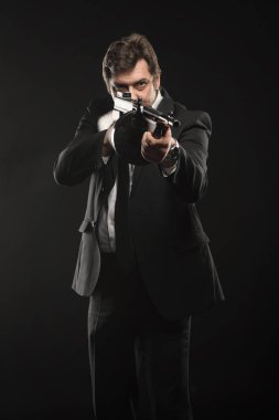 Yakışıklı orta yaşlı adam gangster Thompson makineli tüfek koyu arka plan üzerinde ile