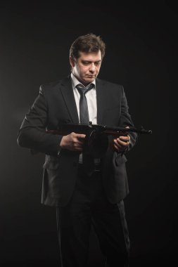Yakışıklı orta yaşlı adam gangster Thompson makineli tüfek koyu arka plan üzerinde ile