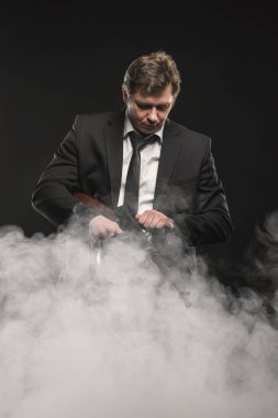 Yakışıklı orta yaşlı adam gangster Thompson makineli tüfek ile sahne duman koyu arka plan üzerinde ile