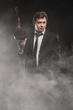 Yakışıklı orta yaşlı adam gangster Thompson makineli tüfek ile sahne duman koyu arka plan üzerinde ile