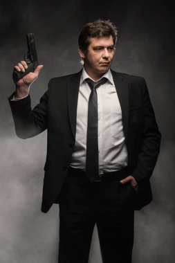 Orta yaşlı dedektif yakışıklı edici top sahne duman ile koyu arka plan