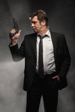 Orta yaşlı dedektif yakışıklı edici top sahne duman ile koyu arka plan