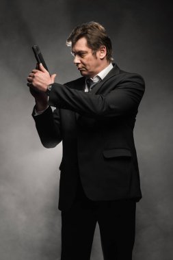 Orta yaşlı dedektif yakışıklı edici top sahne duman ile koyu arka plan