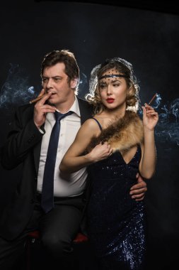 Sigara içen glamour gangster, bir erkek ve kadın sigara duman siyah zemin üzerine ile birkaç