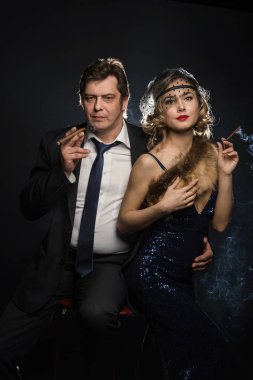 Sigara içen glamour gangster, bir erkek ve kadın sigara duman siyah zemin üzerine ile birkaç
