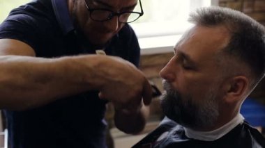 Berber Kuaför dükkanında bir müşteri sakal keser