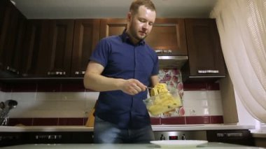 Bir erkek makarna bir tabak içinde koyar.