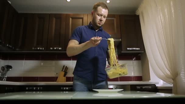 Człowiek stawia spaghetti w płycie — Wideo stockowe