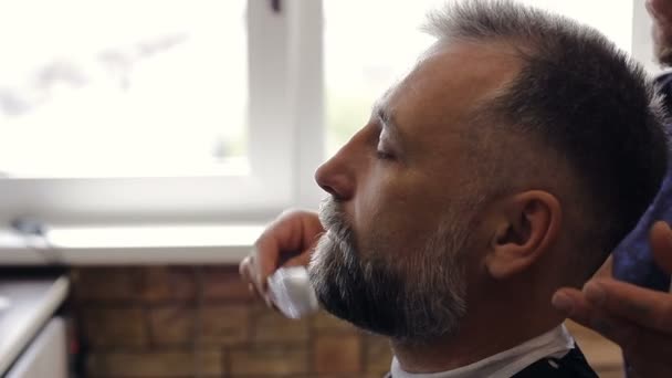 Kapper borstels de baard van de client — Stockvideo