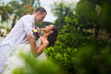 Damat gelini sarıldı ve öpmek için eğildim. Evlilik çift sarılma