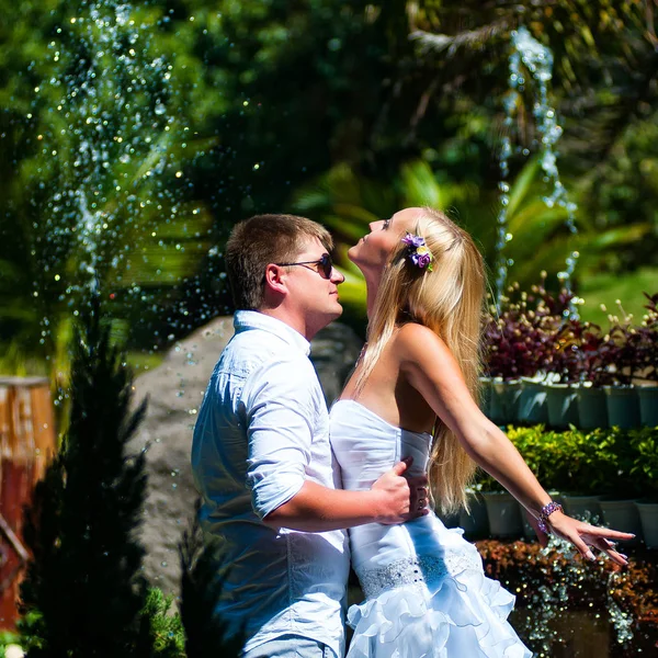 Novio Sostiene Novia Sobre Fondo Fuente Salpica —  Fotos de Stock