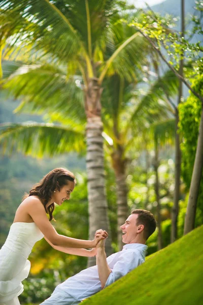 在夏天 新娘和新郎在绿草上享受着对棕榈树的乐趣 — 图库照片