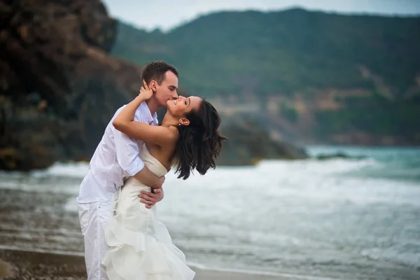 the groom kisses the bride at the sea. couple in love on a deserted beach